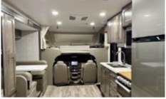 Interior of the Happy Pets Adventure RV showing the kitchen, dinette and bright modern finish